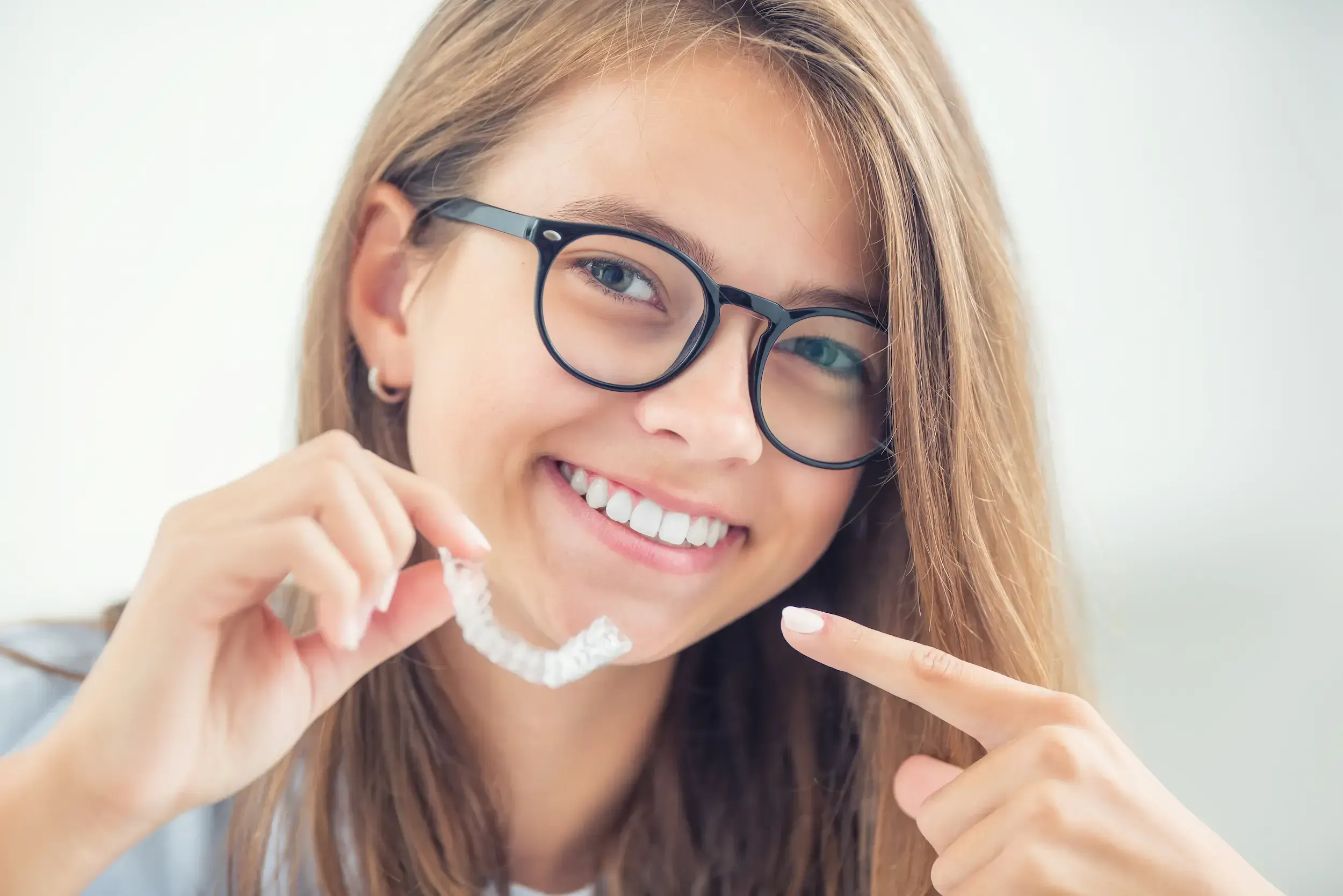 Confident adult patient smiling after completing Invisalign treatment at Cook Family Dentistry