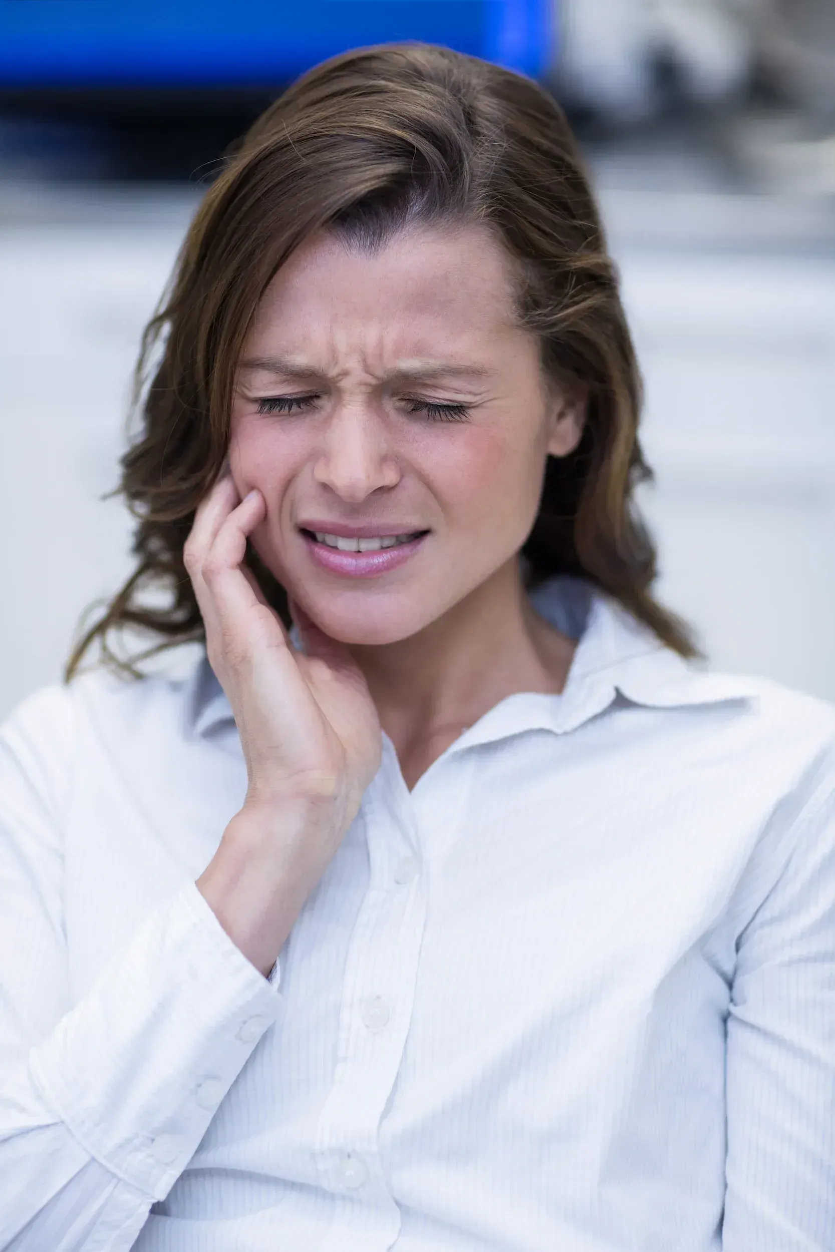 Woman with tension headache and jaw tightness reviewing TMJ symptoms with her dentist in Santa Rosa Beach